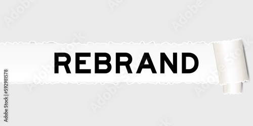 Ripped gray paper background that have word rebrand under torn part