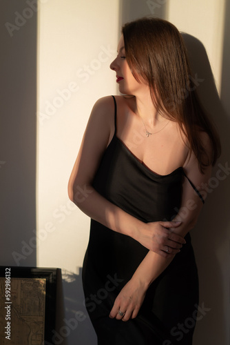 A young woman with red lipstick in a black dress.