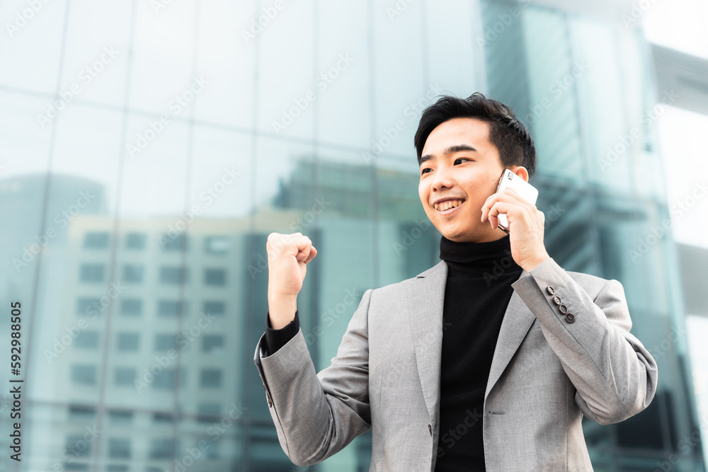 Asian businessman is making a phone call outdoors in the city. Asian businessman is making a phone call outdoors in the city.