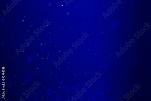 Blue glitter vintage lights background. blue bokeh shiny on dark background.