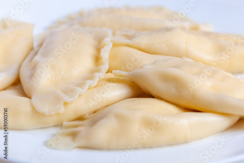 Boiled dumplings with cheese inside on a white plate. Vareniki
