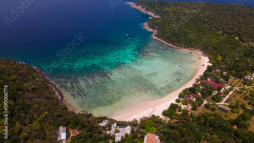 Beautiful beach with colorful water. Top view of the beautiful coastline. Sunny summer day. Colorful water. Sandy beach. © Kooper