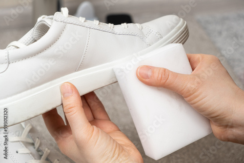Cleaning white shoes and soles from dust and dirt with a melamine sponge photo