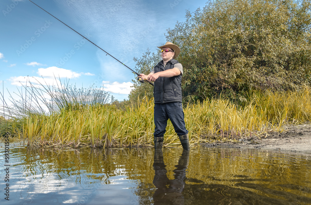 Fisherman in a hat on the river bank Fisherman in a hat on the river bank