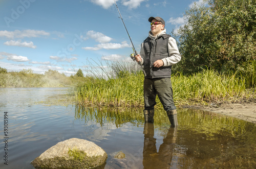Fisherman in a hat on the river bank