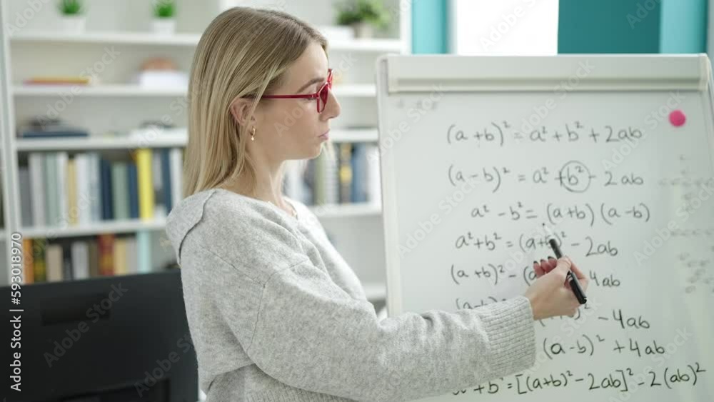 Young blonde woman teaching maths on magnetic board at library university Young blonde woman teaching maths on magnetic board at library university