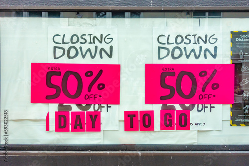 A poster in a shop window advertising 50% discounts as the store is closing down.