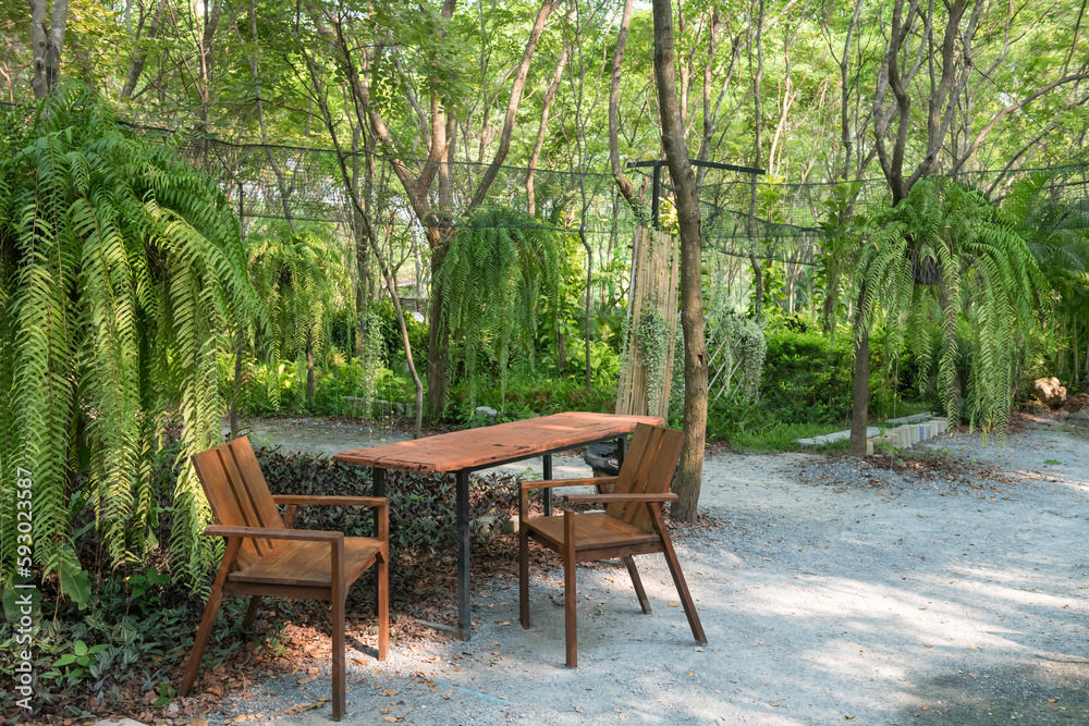 Outdoor wooden table and chairs with with beautiful garden Outdoor wooden table and chairs with with beautiful garden