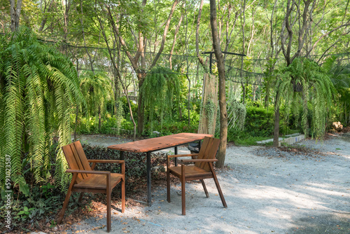 Outdoor wooden table and chairs with with beautiful garden