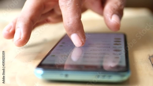 A man hand scrolling a Cell phone screen. Exploring the market on the internet to shop online.