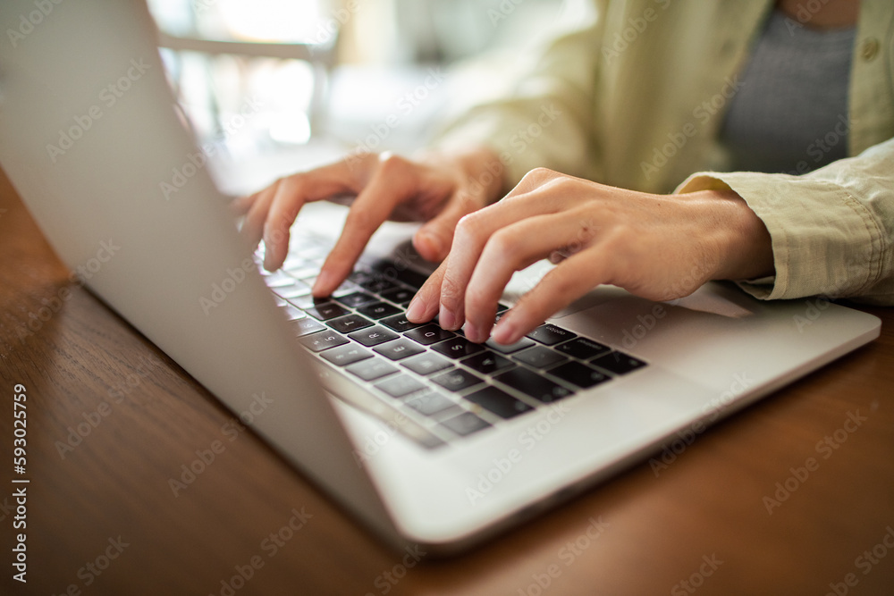 Young Japanese Woman working on a laptop in the kitchen Young Japanese Woman working on a laptop in the kitchen