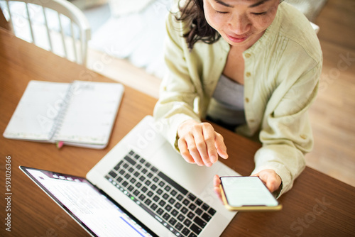 Young Japanese woman using a smart phone in the living room