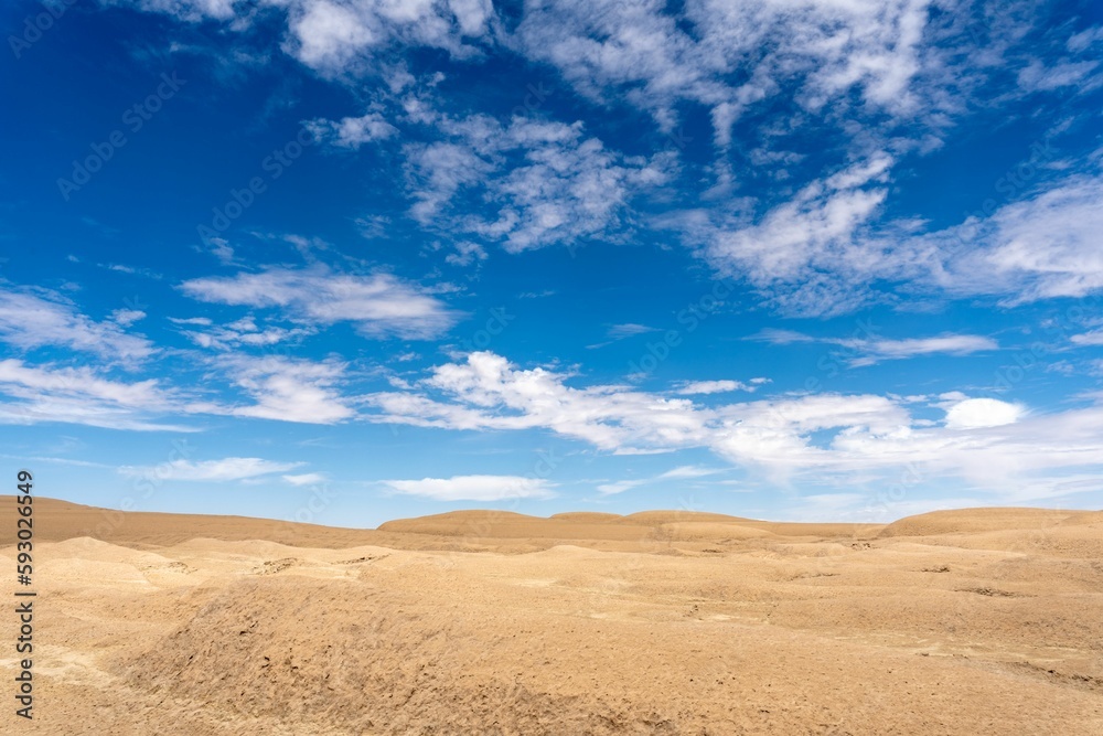 Landscape of a deserted area captured below the blue sky with a scattered cloudscape Landscape of a deserted area captured below the blue sky with a scattered cloudscape