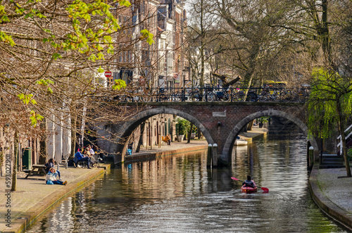 Utrecht, The Netherlands, April 9, 2023: people enjoying the springtime sun and others canooing on the water of the Oude Gracht (Old Canal)