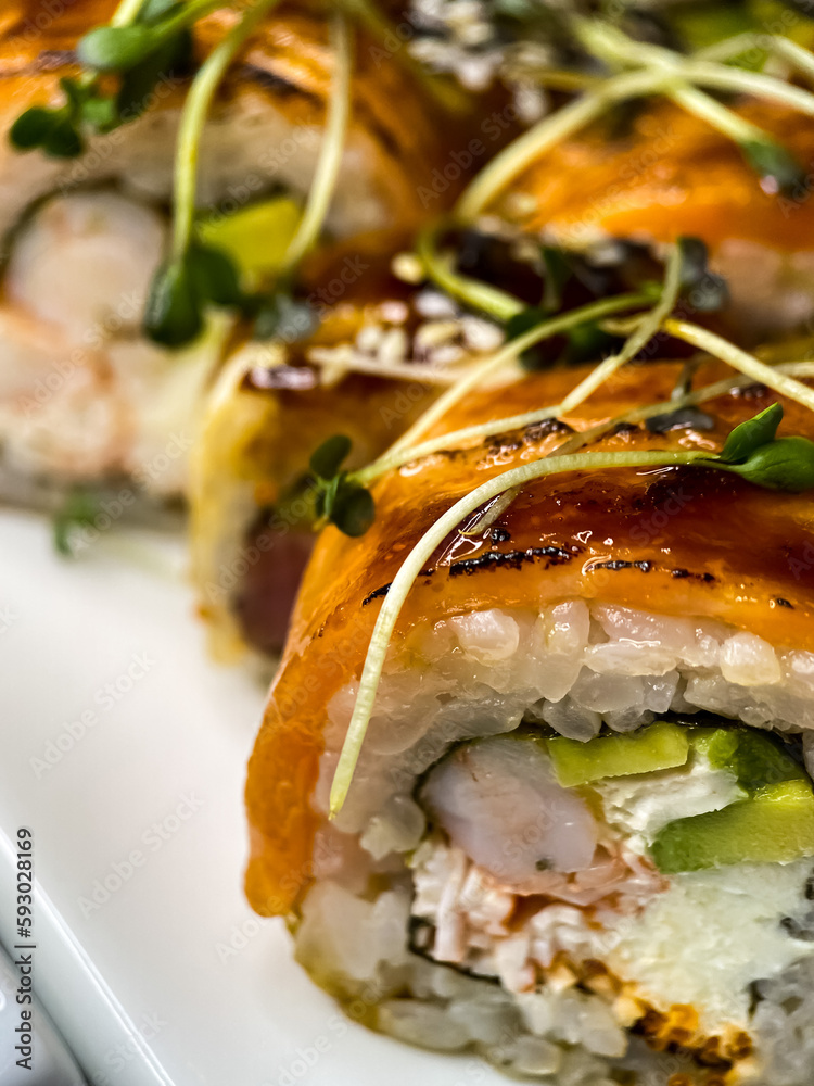 sushi and rolls on the white Japanese plate on black background