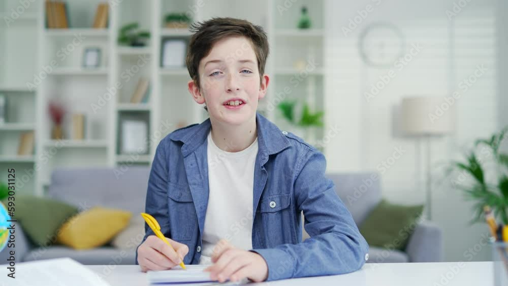 A Child school boy, a schoolboy talks while answering questions in an online lesson. learns remotely by video call, speek looks at the computer camera. View of the webcam at home remote distant lesson A Child school boy, a schoolboy talks while answering questions in an online lesson. learns remotely by video call, speek looks at the computer camera. View of the webcam at home remote distant lesson