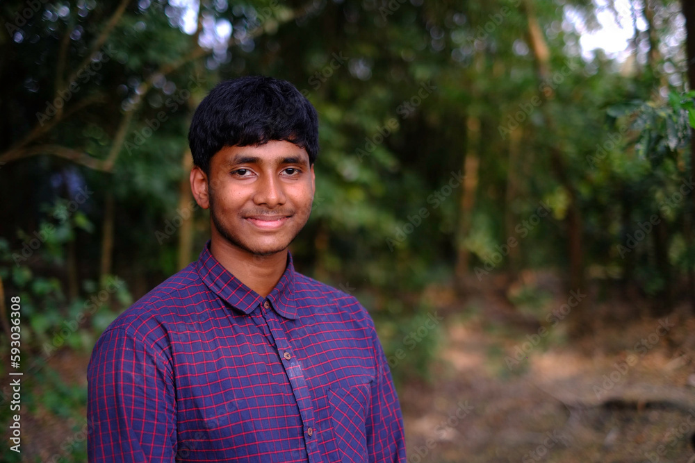 South asian young male teenage boy posing wearing shirt into rthe nature , portrait with negative space concept South asian young male teenage boy posing wearing shirt into rthe nature , portrait with negative space concept