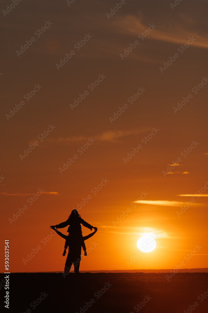 silhouettes of couple at sunset against bright sun sky. man and woman have fun in nature, walking and relaxing, relationships and falling in love. poster postcard romantic meetings against background 