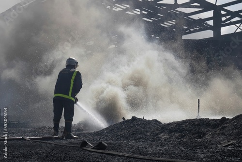 Male firefighter spraying high pressure water