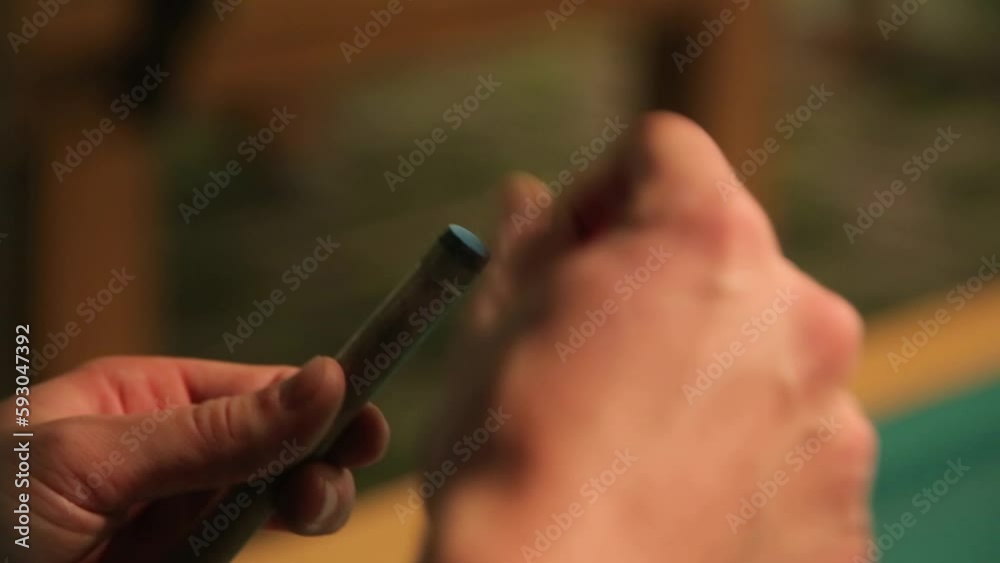 Billiard player wipes the tip of the cue with a chalk Billiard player wipes the tip of the cue with a chalk