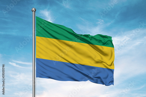 Gabon national flag cloth fabric waving on beautiful sky Background. photo
