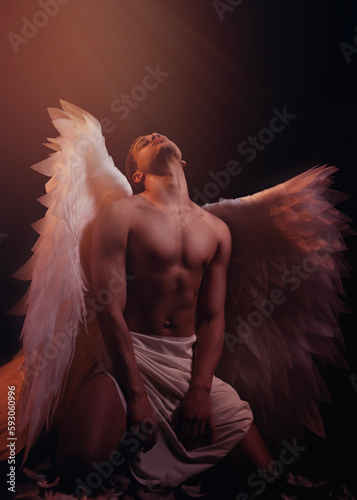 Young strong angel with white wings from heaven. Angel with muscular body. Sensual man