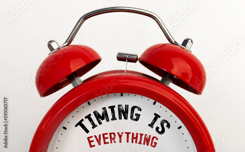 Red alarm clock with text Timing is Everything