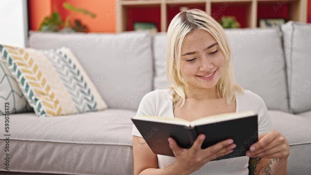 Young beautiful hispanic woman reading book sitting on floor at home Young beautiful hispanic woman reading book sitting on floor at home