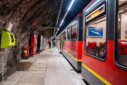 Passengers standing outside train at Jungfrau railway station in mountain tunnel inside Bernese Alps, Switzerland, winter holiday travel concept photo