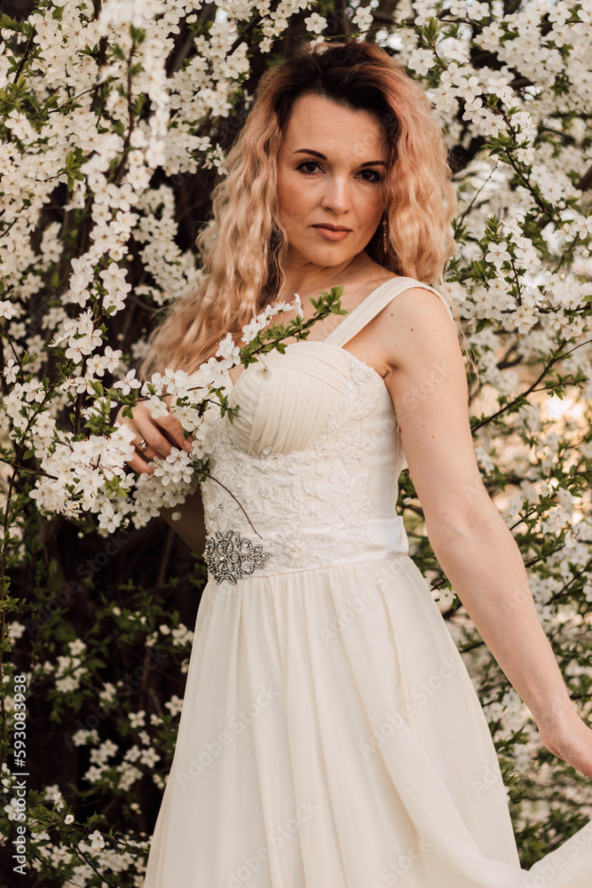 A beautiful bride near a cherry blossom. Spring Wedding