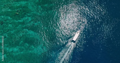 Aerial drone footage of speedboat on turquoise lagoon and coral reef of Gili Meno tropical island, Indonesia 