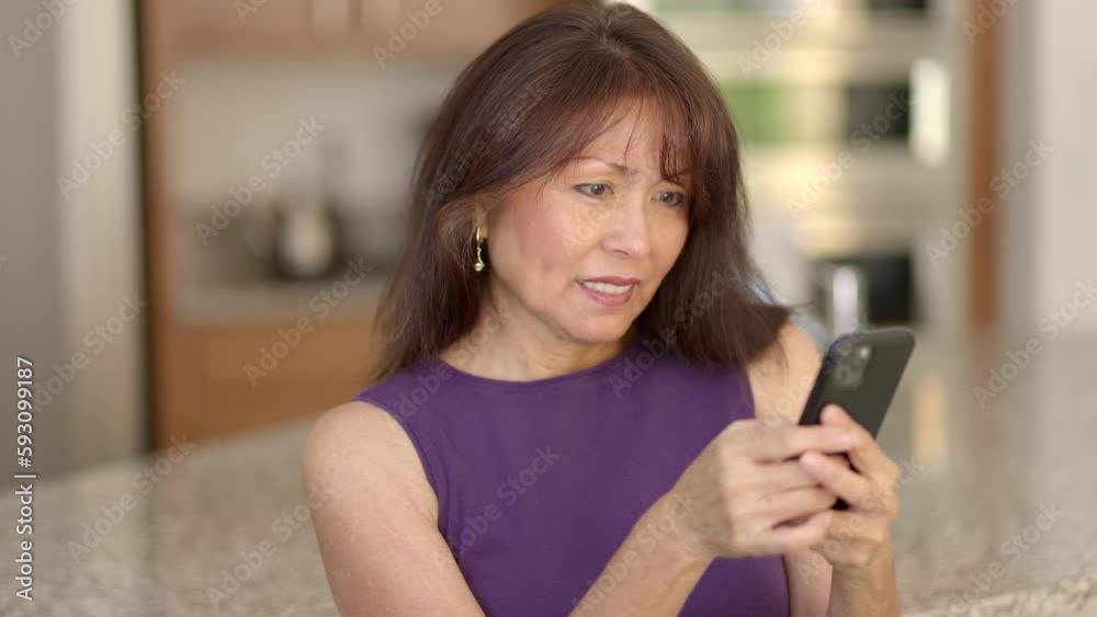 Close up attractive woman enjoying texting email on mobile cell phone sitting in home kitchen Close up attractive woman enjoying texting email on mobile cell phone sitting in home kitchen