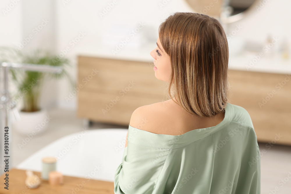 Woman wearing stylish robe in bathroom, back view. Space for text Woman wearing stylish robe in bathroom, back view. Space for text