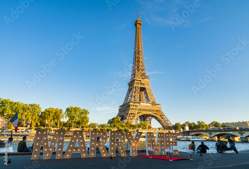 Marry me inscription and Eiffel Tower in golden hour light in Paris. France 