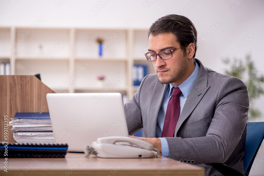 Young male employee working in the office Young male employee working in the office