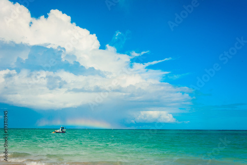 A rainbow over the sea on a sunny day with blue sky