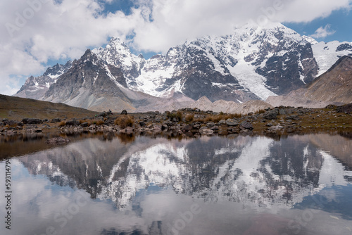 Young hikers on the ausangate circuit in front of the snow-covered peak, Ausangate 6384m, Cordillera Vilcanota, Peru, South America photo