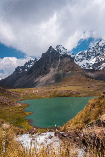 Large hanging glaciers on the eastern face of Nevado Ausangate above permanent houses at 4900 m, Ausangate trek, Peru, South America.