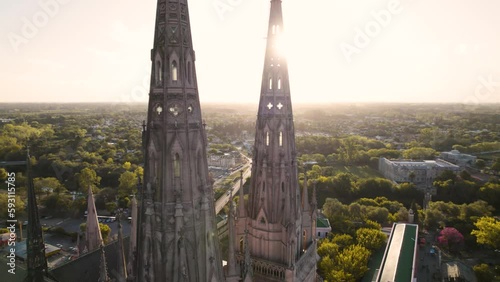 video aéreo 4k de puntas de torre de catedral, con el sol de fondo al atardecer, lujan, buenos aires, argentina photo