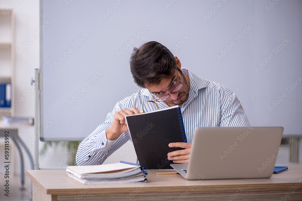 Young male teacher sitting in the classroom Young male teacher sitting in the classroom