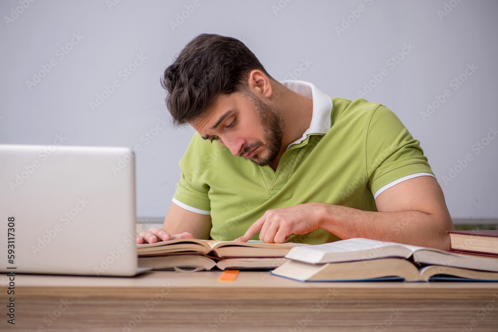 Young male student sitting in front of whiteboard Young male student sitting in front of whiteboard
