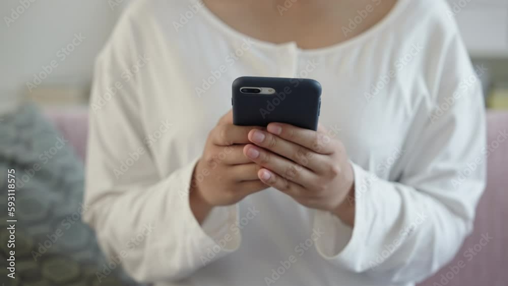 Hand of Asian girl using send mobile phone or chat indoor at home. Close up of young woman hand Hand of Asian girl using send mobile phone or chat indoor at home. Close up of young woman hand