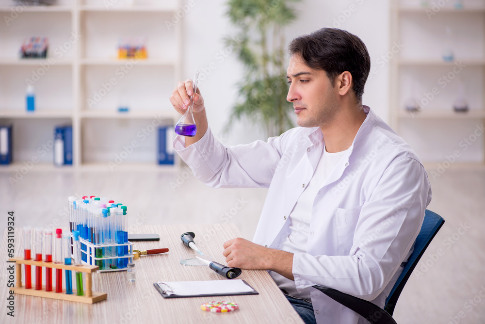 Young male chemist working at the lab Young male chemist working at the lab