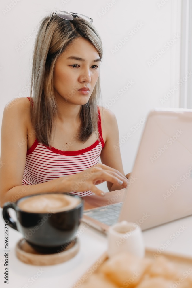 Freelance asian girl seriously working on computer in the cafe. Freelance asian girl seriously working on computer in the cafe.
