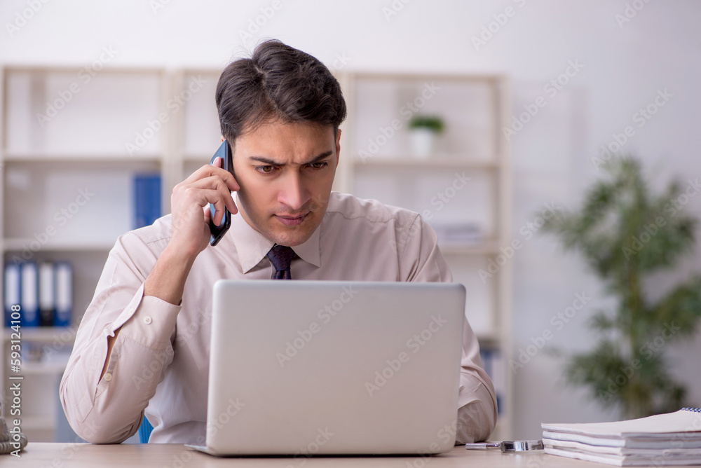 Young male employee working in the office Young male employee working in the office