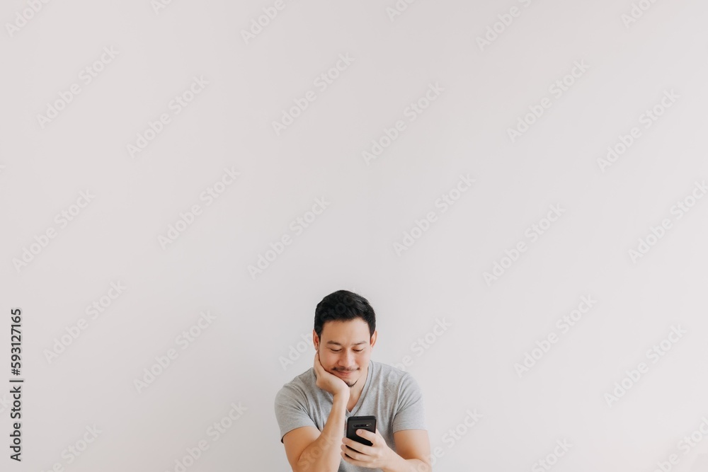 Minimal portrait of Asian man using smartphone at the bottom with empty space. Minimal portrait of Asian man using smartphone at the bottom with empty space.