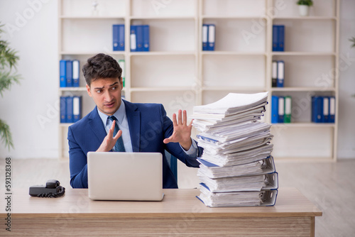 Young male employee and too much work in the office