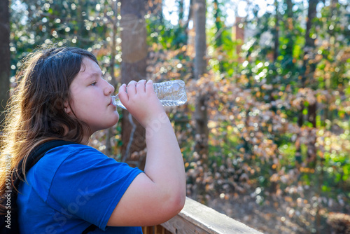 Girl drinking water from a bottle in the park
