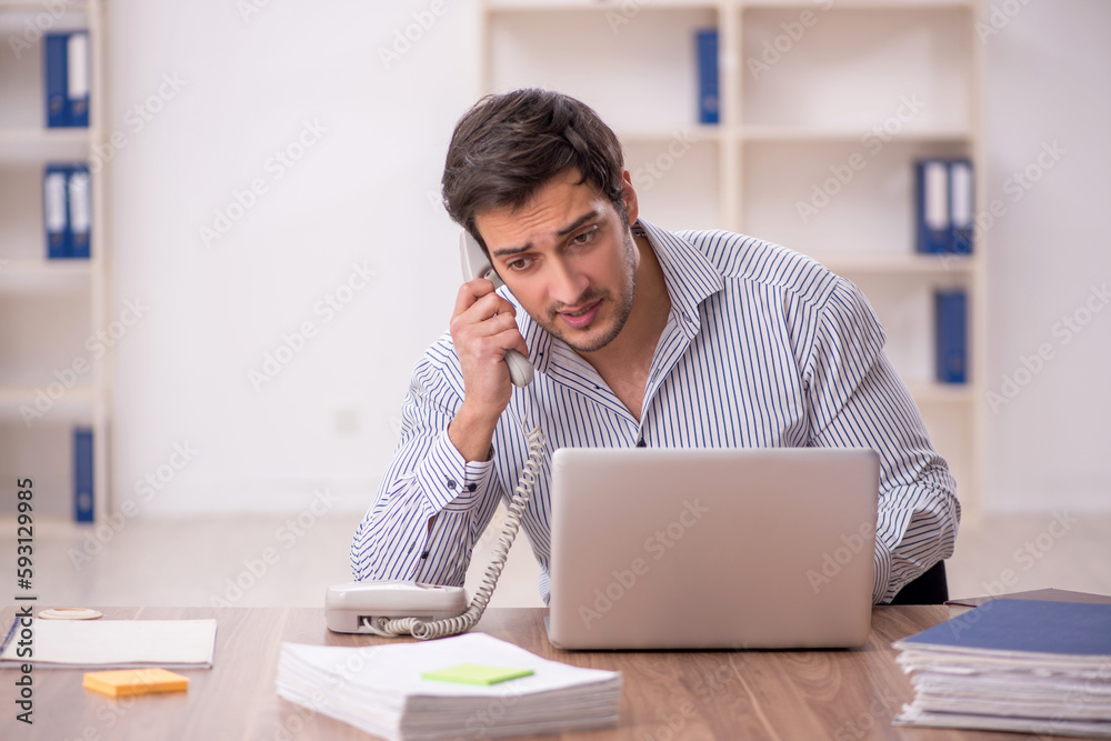 Young male employee working in the office Young male employee working in the office