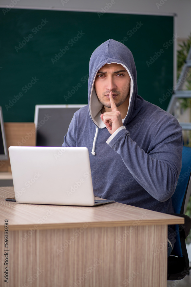Young male hacker sitting in the classroom Young male hacker sitting in the classroom